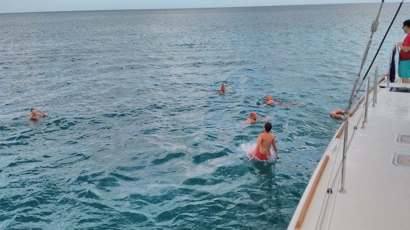 family throwing themselves into the sea from the boat